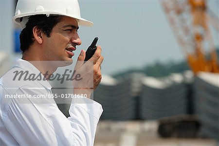 Man in work uniform, talking into walkie talkie