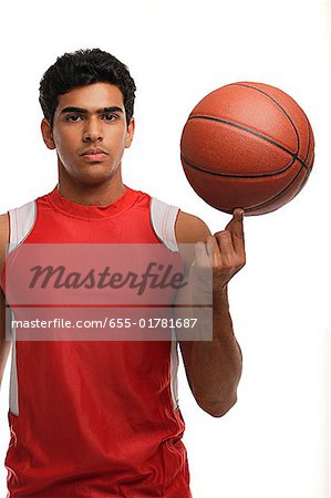 Jeune homme au basket-ball en regardant la caméra