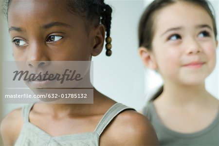 Close-up of girl looking away, friend looking up and smiling in background