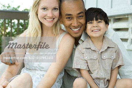 Family smiling at camera together, portrait