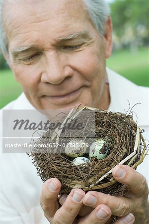 Senior homme tenant des nids d'hirondelle, gros plan