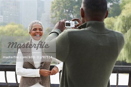 Homme qui prend la photo de la femme par l'eau, New York City, New York, USA