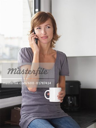 Woman in Kitchen with Cellular Phone, Paris, France