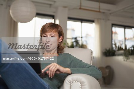 Femme en fauteuil avec ordinateur portable