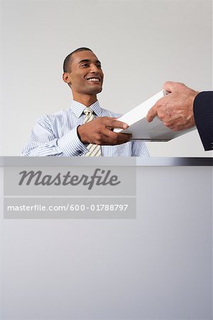 Receptionist Giving Papers to Businessman