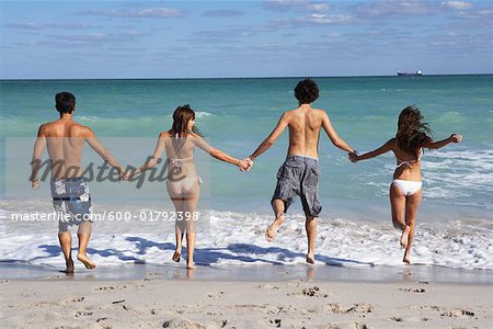 Gruppe von Menschen am Strand laufen