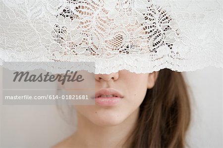 Femme derrière un rideau de net