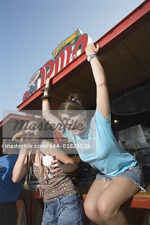 Two female teenagers hanging out, eating pizza