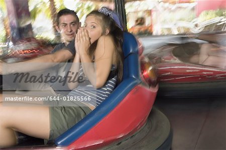 Couple d'adolescents dans des autos tamponneuses dans le parc d'attractions
