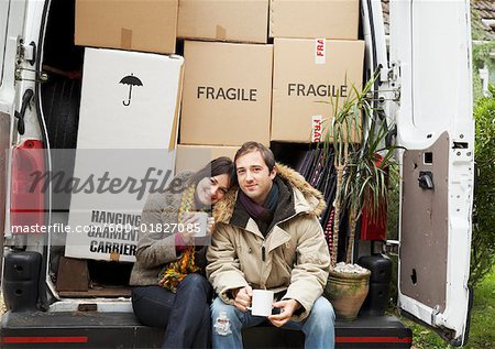 Couple Sitting on Back of Moving Van
