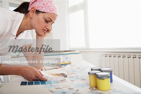 Femme regardant de papier peint et peinture nuancier