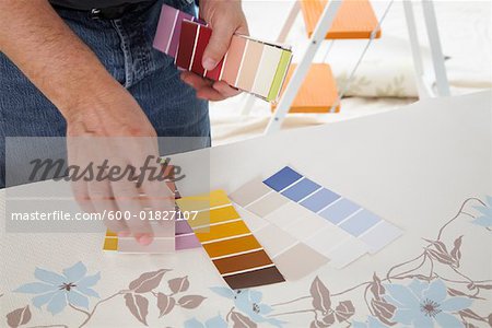 Homme avec des échantillons de peinture et papier peint