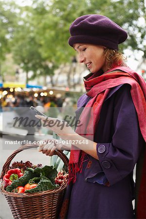 Frau mit Handy am Markt