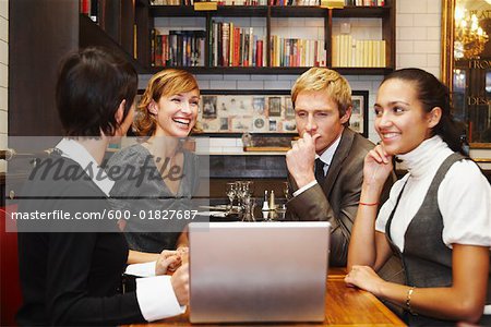 Gens d'affaires avec ordinateur portable dans le Cafe