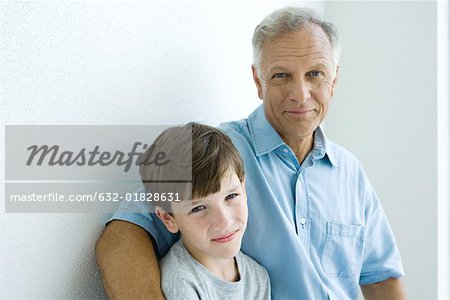 Grandfather and grandson smiling at camera together, portrait