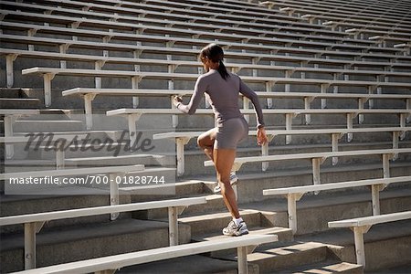 Woman Jogging up Bleacher Steps