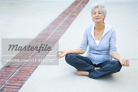 Senior Woman sitting im Lotussitz, Augen geschlossen