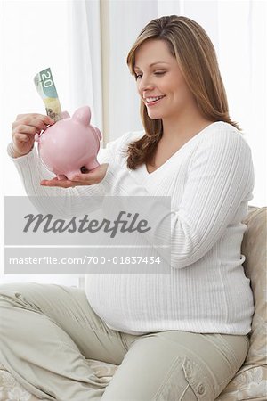 Pregnant Woman Putting Money in Piggy Bank