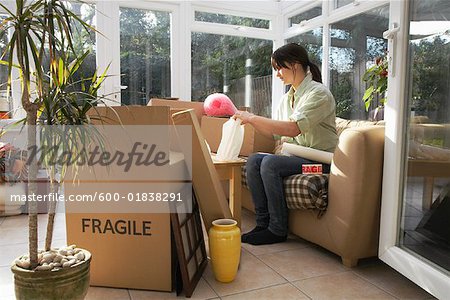 Woman Packing Boxes in Sunroom