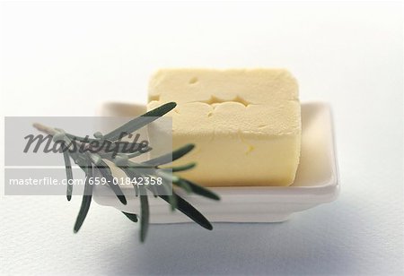 Fresh Butter in a White Butter Dish with Rosemary