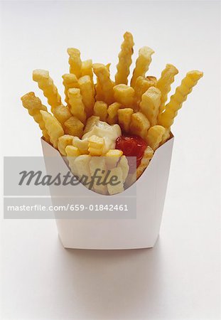 Frites, coupe-frites dans une boîte blanche avec le Ketchup et la Mayonnaise