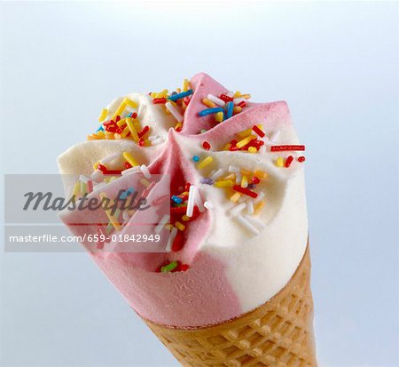 Strawberry and vanilla ice cream with sprinkles in cone