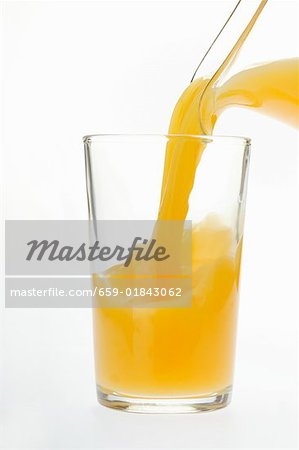 Verser le jus d'orange dans le verre de jus