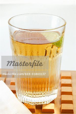 Apple juice with wedge of lime in glass