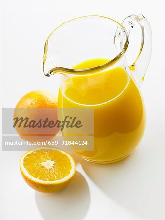 Orangensaft im Glaskanne, frischen Orangen