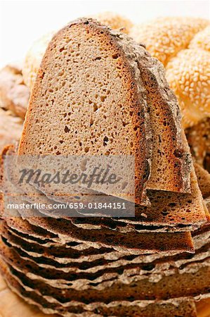 Scheiben Bauernbrot in einem Haufen vor assortierte Brötchen