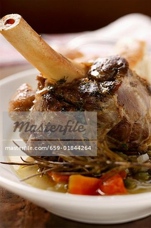 Braised lamb shank with vegetables & rosemary on plate