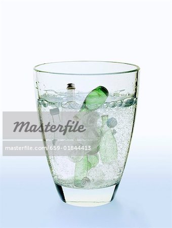Image symbolique : bouteilles d'eau dans un verre d'eau