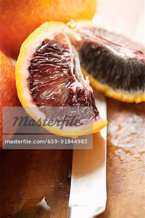 Wedges of blood orange on knife