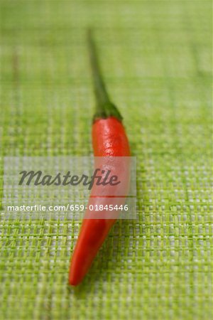 Red chili pepper on green background