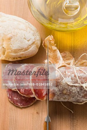 Italian salami with slices cut, white bread, olive oil