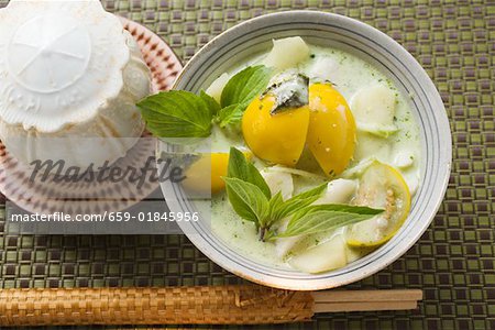 Coconut soup with potatoes, fish, Thai aubergines, basil