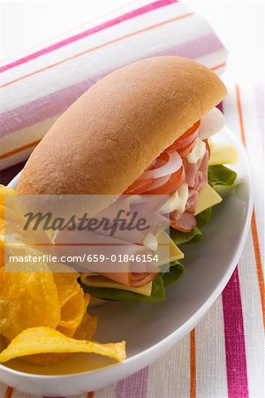 Ham, cheese, tomato and onion in sub sandwich with crisps