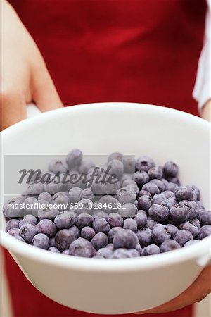 Person holding pan of fresh blueberries