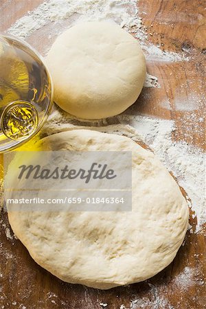 Uncooked dough, rolled out and in a ball, olive oil