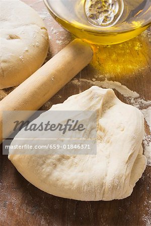 Dough, rolling pin, ball of dough and olive oil