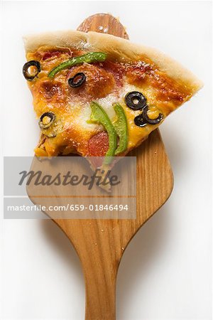 Piece of pizza with cheese, salami, peppers, olives on server