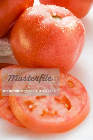 Tomatoes, whole and slices, with drops of water