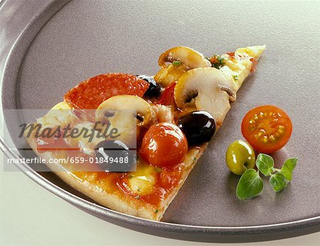 Un morceau de pizza salami sur une plaque à pizza