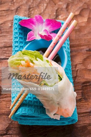 Rice paper roll with soy sauce, chopsticks and orchid