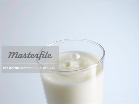 A glass of milk with drops of milk