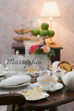 Tee-Dinge und Butterdose am schön gedeckten Tisch