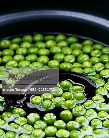 Petits pois dans un bol d'eau