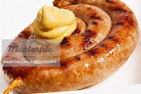 Coiled sausage with blob of mustard