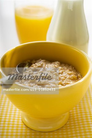 Porridge, milk and orange juice behind