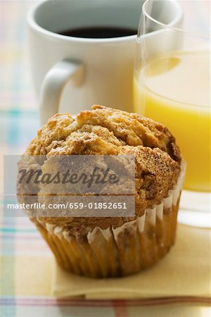 Muffin, Orangensaft und Kaffee hinter